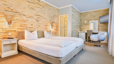 Wohlfühlzimmer Solnhofener mit einer Wand aus Solnhofener Naturstein, Doppelbett.