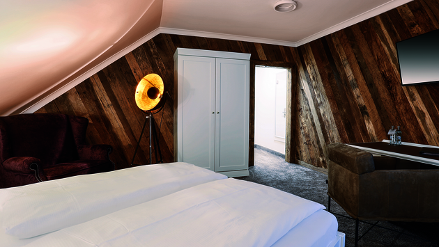 Wohlfühlzimmer Historische Eiche mit einer Wand aus 500 Jahre alten Eichenbalken.