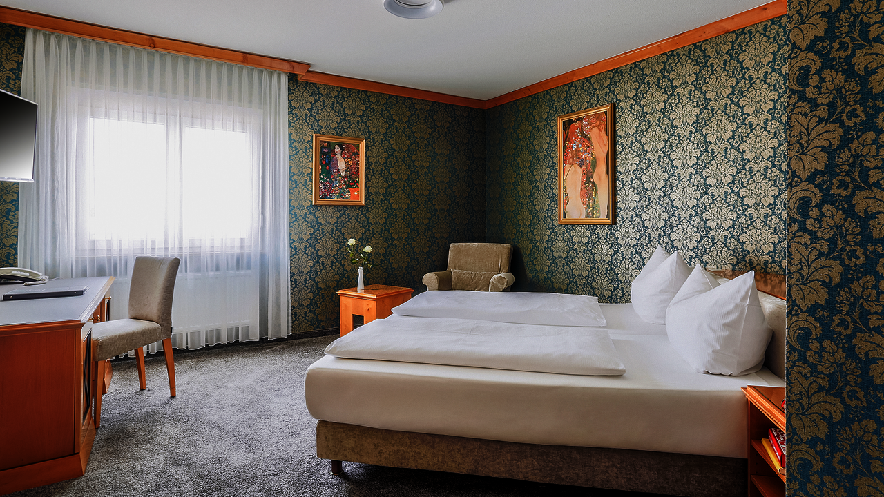Wohlfühlzimmer Stil mit einer petrolfarbenen Tapete mit goldenen Ornamenten